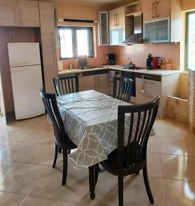 a kitchen with a table and chairs and a refrigerator at MARMARI Village in Ayía Marína