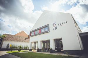 un edificio blanco con la señal de mercado inteligente en él en Smart Hotel, en Körösladány