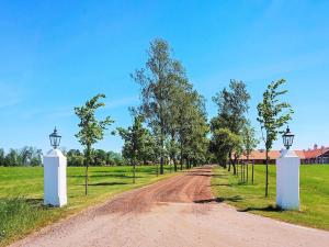 un camino de tierra con dos puertas blancas y árboles en 4 person holiday home in HOVA, en Hova