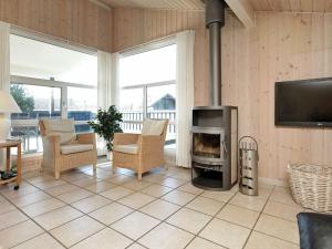 a living room with a fireplace and a television at 6 person holiday home in Henne in Henne Strand