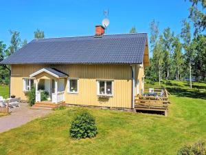 a small yellow house on a grassy field at 14 person holiday home in HOVA in Hova