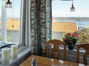 ein Esszimmer mit einem Tisch, 2 Stühlen und einem Fenster in der Unterkunft 3 person holiday home in Gullholmen in Gullholmen