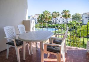 a table and chairs on a balcony with a view of a pool at Great 2 Bedroom Apartment Near Puerto Banus in Marbella