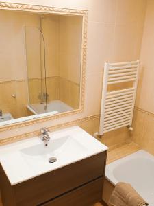Estudio Vigo Centro Lux في فيغو: حمام مع حوض ومرآة