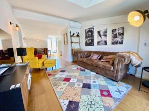 sala de estar con sofá marrón y alfombra en Unique apartment by MyPlaceForYou, in the center of Lisbon with views over the city and the Tagus river en Lisboa