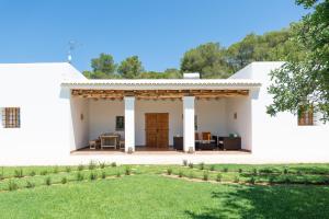 ein weißes Haus mit einer Terrasse und einem Hof in der Unterkunft Casa rural es Murtà in Santa Eulària des Riu