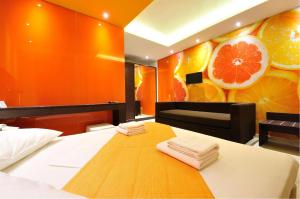 a bedroom with a bed and a painting of oranges at Louloudis Fresh-Adults Only in Skala Rachoniou