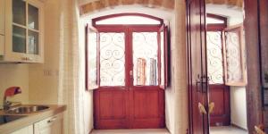 a red door in a kitchen with a window at Joy's Home in Bari