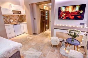 a kitchen with a fireplace and a table with flowers at Apartments Marconio Wellness Club in Belgrade
