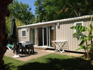 滨海阿热莱斯TOPSUN Argelès La Sirène 3 bedroom Max 4 adulte et 2 des ses enfants的一个带桌子的庭院和一座建筑
