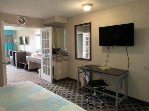 Habitación de hotel con cama, escritorio y TV. en Travelodge by Wyndham San Antonio Downtown Northeast, en San Antonio