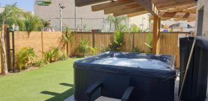 a hot tub in a yard with a chair at Avshalom Holiday Apartments in Eilat