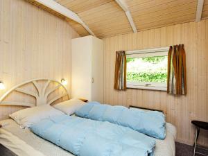 1 dormitorio con 1 cama grande con almohadas azules en Holiday Home Bygmarken III, en Binderup Strand