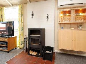 Binderup StrandにあるHoliday Home Bygmarken IIIの壁に暖炉がある部屋
