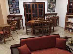 a living room with a couch and tables and chairs at Cavo Paradiso Villa in Asprovalta