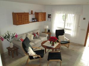 sala de estar con sofá, mesa y sillas en Casa Yvonne, en Rojales