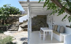 a white house with a white table and chairs at The stone in Tinos +6 photos