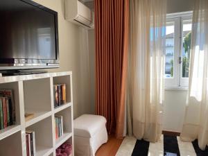 a living room with a tv and a window at Central House in Ponta Delgada
