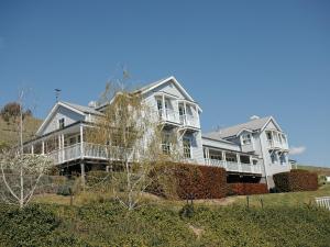 una grande casa bianca su una collina con alberi di Nimbo Fork Lodge a Gocup