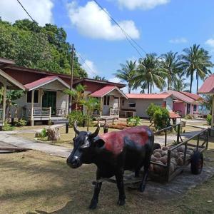 a statue of a cow pulling a cart at Tamara Village Tioman in Kampong Juara