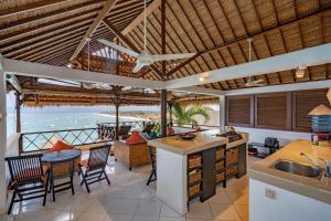 cocina abierta y zona de comedor con vistas al océano en Villa Atas Lembongan, en Nusa Lembongan