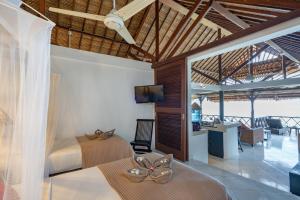um quarto com 2 camas, uma secretária e uma televisão em Villa Atas Lembongan em Nusa Lembongan