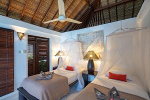 a bedroom with two beds and a ceiling fan at Villa Atas Lembongan in Nusa Lembongan +53 photos