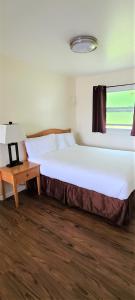 a bedroom with a large white bed and a table at Blue Coast Inn & Suites in Brookings