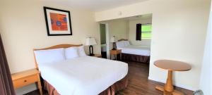 Habitación de hotel con cama y espejo en Blue Coast Inn & Suites, en Brookings