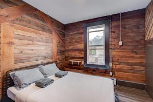 a bedroom with a bed in a room with wooden walls at PARTY HOSTEL - The Canmore Hotel Hostel in Canmore