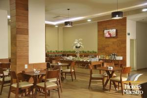 ein Restaurant mit Tischen und Stühlen in einem Zimmer in der Unterkunft Hotel Maestro Premium Cascavel in Cascavel