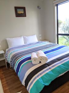 a bed with a blue blanket and pillows on it at BIG4 Aireys Inlet in Aireys Inlet