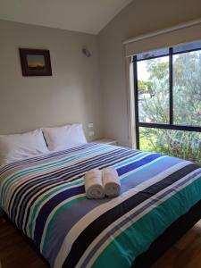 a bed room with a blue and white striped bedspread at BIG4 Aireys Inlet in Aireys Inlet