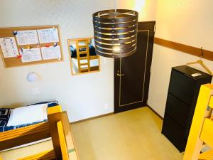 a kitchen area with a refrigerator, stove, and cabinets at Khaosan Tokyo Origami in Tokyo