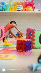 Ein kleiner Junge, der mit Spielsachen auf dem Boden spielt. in der Unterkunft Salinas Parks in Salinópolis
