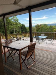 a wooden deck with a table and chairs on it at daintree valley cottage in Daintree