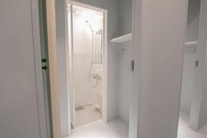 een badkamer met douche en glazen deur bij Theatel Sapporo in Sapporo +3 foto's