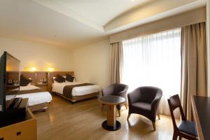 a hotel room with two beds and a television at Hotel Nagoya Garden Palace in Nagoya