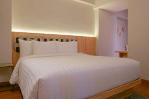 a bedroom with a large white bed with white pillows at PULANG ke UTTARA in Yogyakarta