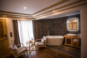 a bathroom with a tub and a table and chairs at Lijiang Yunqi Holiday Guesthouse in Lijiang