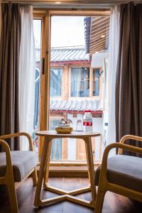 a table and two chairs in front of a window at Lijiang Yunqi Holiday Guesthouse in Lijiang