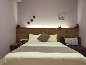 een slaapkamer met een groot bed met een houten hoofdeinde bij Mysig in Luodong