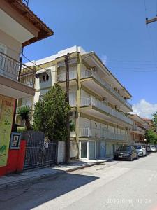 an apartment building with cars parked in front of it at Apartment Marina 2 in Asprovalta