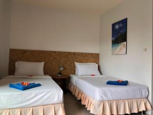 dos camas sentadas una al lado de la otra en una habitación en Baan Anattaya Koh yao noi, en Ko Yao Noi