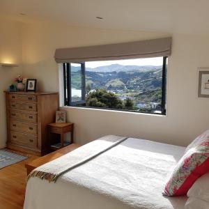 1 dormitorio con ventana grande con vistas a la montaña en The Rectangle Apartment, Akaroa, en Akaroa