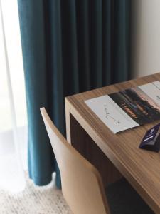 Hotel Termalny في يونيجوو: طاولة خشبية مع كرسي بجوار مكتب