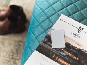 a close up of the inside of a turquoise clutch with a white card at Hotel Termalny in Uniejow