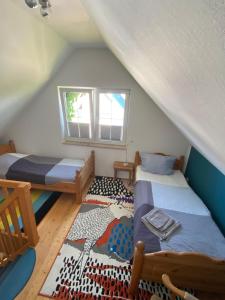 a attic room with two beds and a rug at Haus Meere´s Stille in Zingst