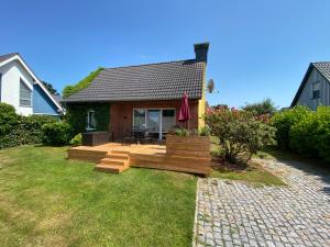 ツィングストにあるHaus Meere´s Stilleの庭に木製のデッキがある家