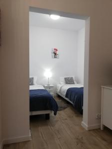 sypialnia z 2 łóżkami i lustrem w obiekcie Leśny Apartament II w mieście Szczytno